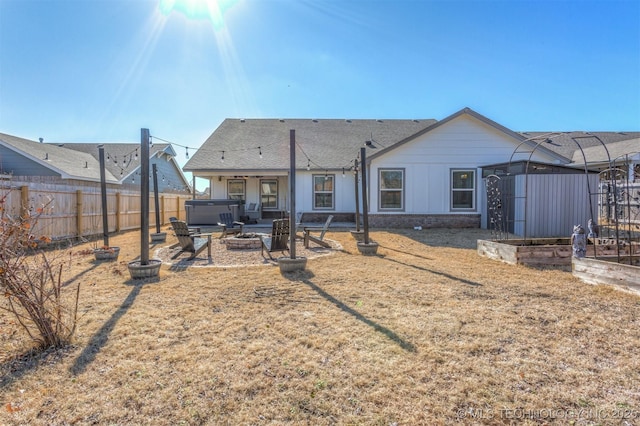 rear view of house featuring a gazebo and a hot tub