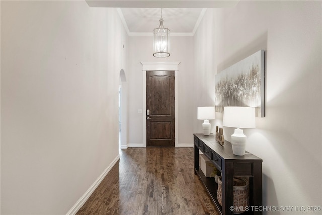 entrance foyer featuring a notable chandelier, dark wood-type flooring, and ornamental molding