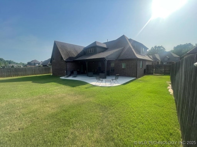 rear view of property featuring a patio and a lawn