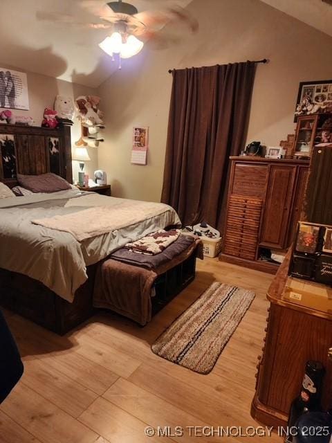 bedroom featuring ceiling fan, lofted ceiling, and light hardwood / wood-style floors