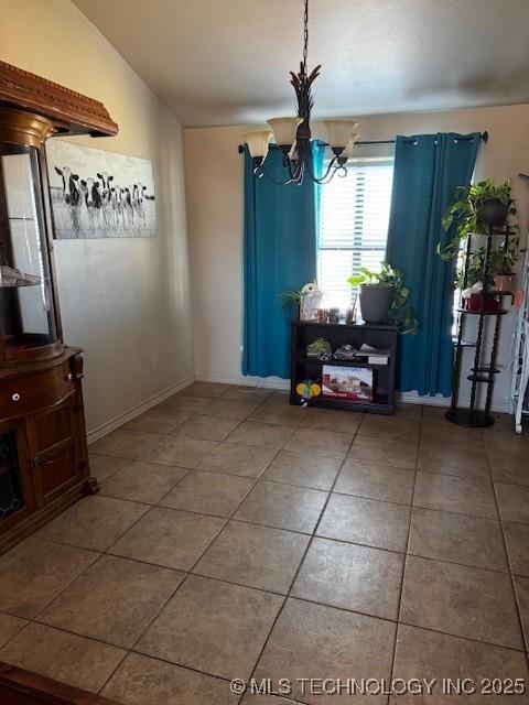 tiled dining area featuring lofted ceiling and a notable chandelier