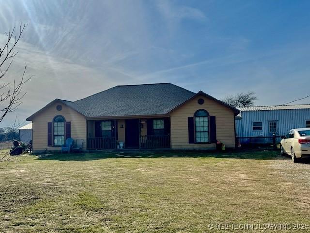 ranch-style house with a porch and a front lawn