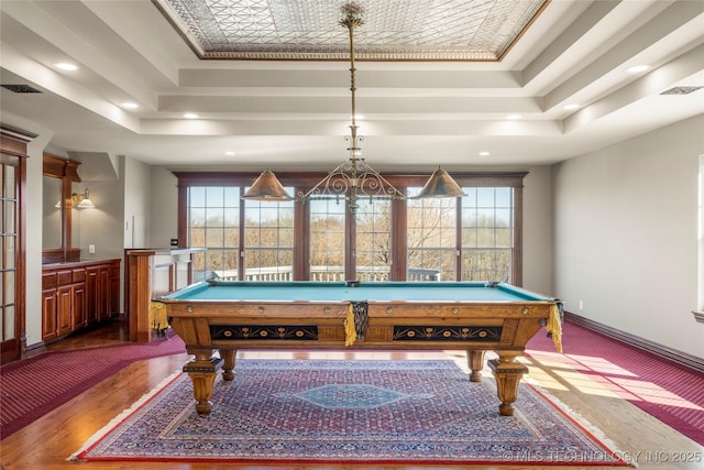 game room with billiards, a tray ceiling, and hardwood / wood-style floors