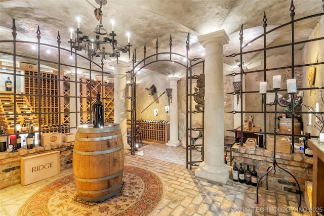 wine room with decorative columns and a notable chandelier