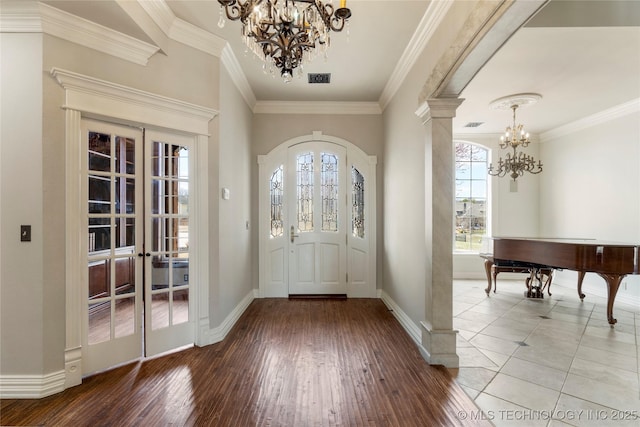 entryway featuring crown molding, french doors, a chandelier, and hardwood / wood-style flooring