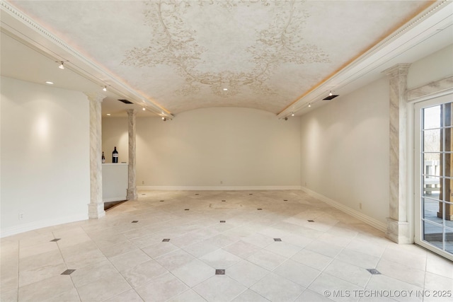 empty room with lofted ceiling and decorative columns