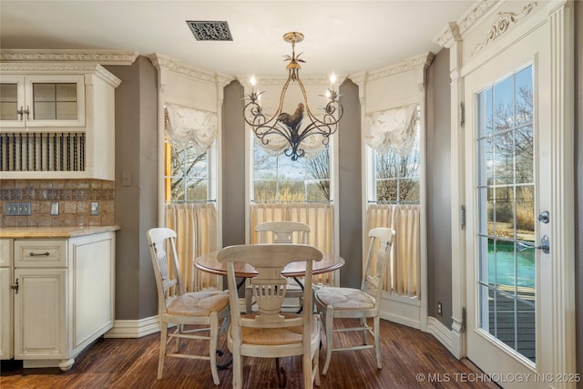 dining room featuring dark hardwood / wood-style floors, a wealth of natural light, and a notable chandelier