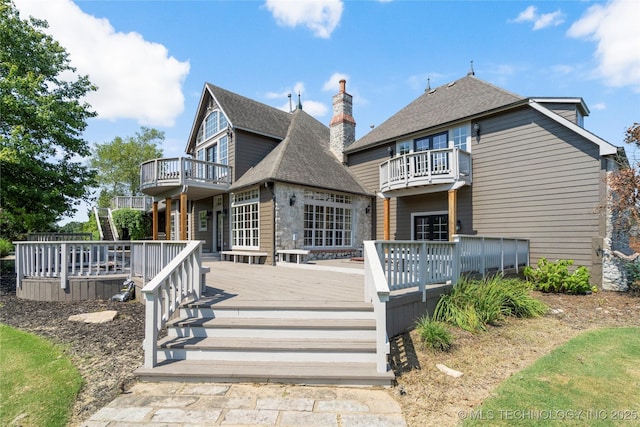 rear view of property with a wooden deck and a balcony