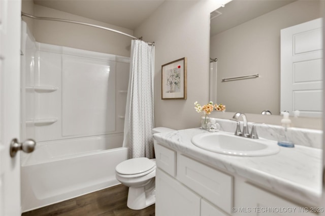 bathroom featuring toilet, shower / bath combo with shower curtain, wood finished floors, and vanity