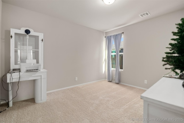 office space featuring light carpet, visible vents, and baseboards