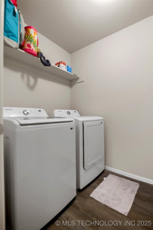 laundry area with dark wood-style floors, washing machine and dryer, laundry area, and baseboards