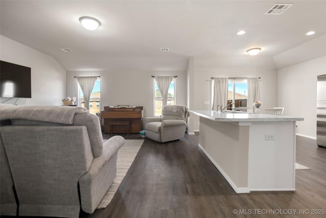 living room with lofted ceiling, dark wood-style flooring, visible vents, and baseboards