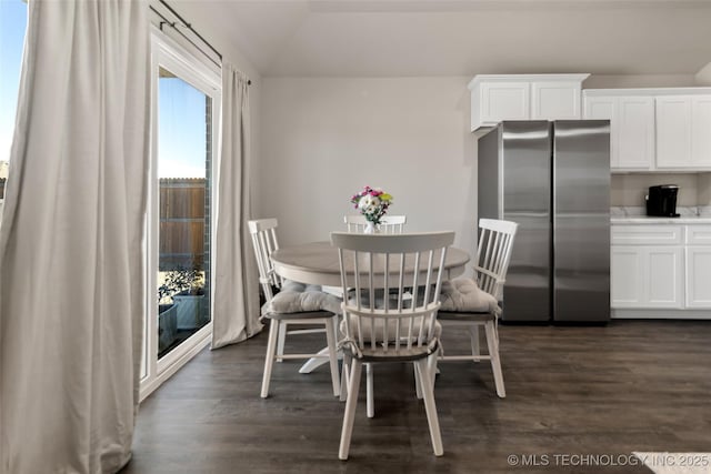 dining space with dark wood-style floors and vaulted ceiling