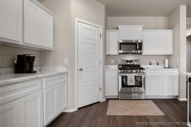 kitchen featuring appliances with stainless steel finishes, light countertops, white cabinetry, and dark wood-style floors