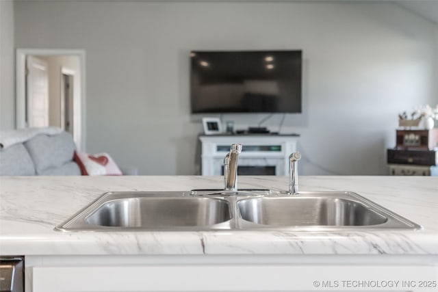 interior space with light stone countertops, dishwasher, and a sink