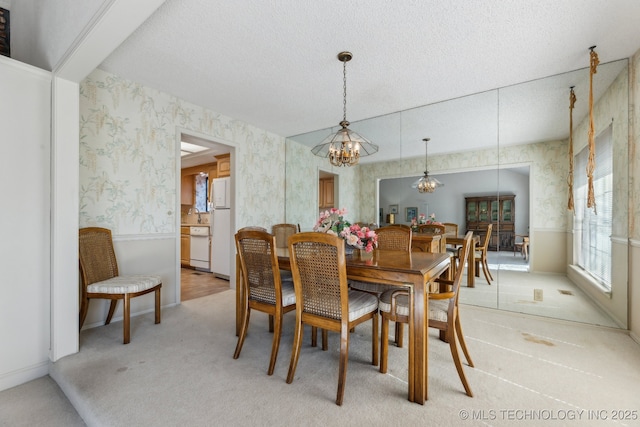 dining space with carpet, a textured ceiling, and a notable chandelier