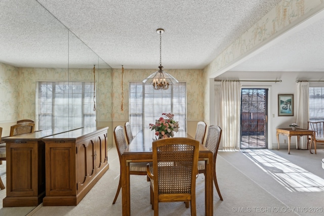 carpeted dining area featuring an inviting chandelier and a textured ceiling