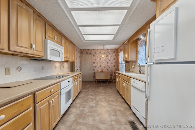 kitchen featuring sink, white appliances, decorative light fixtures, and decorative backsplash