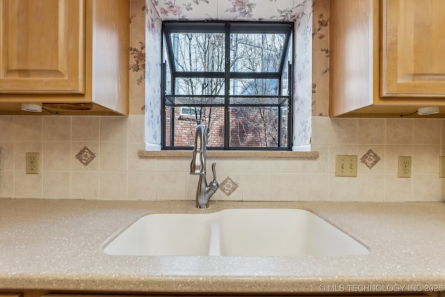 kitchen with light stone counters, sink, decorative backsplash, and light brown cabinets