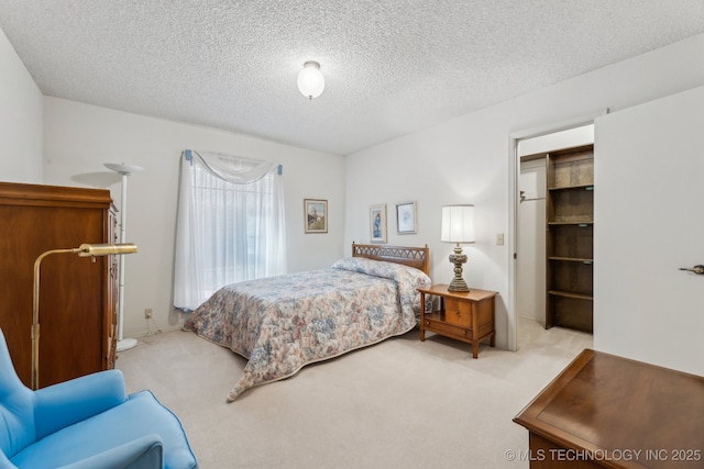 bedroom with light carpet and a textured ceiling