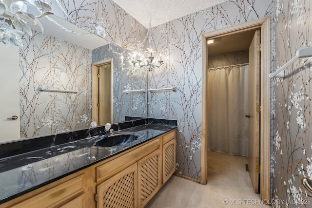 bathroom featuring vanity, a notable chandelier, and a textured ceiling