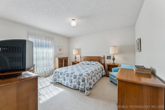 bedroom with a textured ceiling and carpet flooring