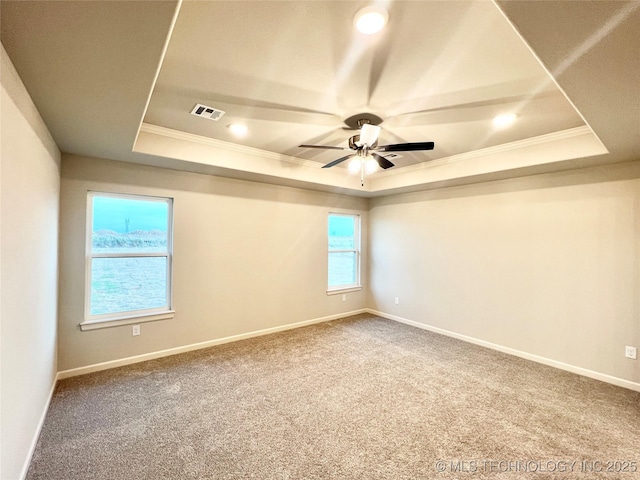 carpeted empty room with ceiling fan, ornamental molding, and a tray ceiling