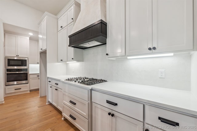 2722 E 134th Cir, Bixby, OK 74008 - kitchen featuring stainless steel appliances, custom exhaust hood, white cabinets, and backsplash