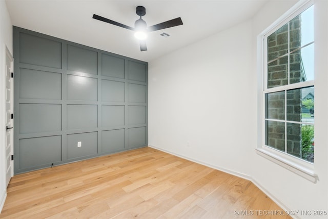 2722 E 134th Cir, Bixby, OK 74008 - empty room featuring a decorative wall, a ceiling fan, and light wood-type flooring
