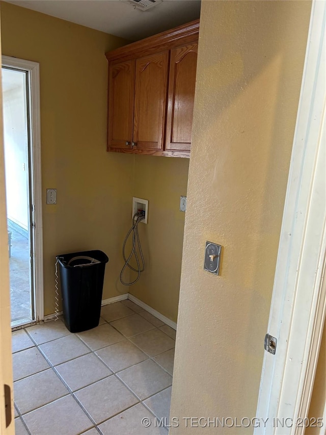 washroom with cabinets, light tile patterned flooring, and washer hookup