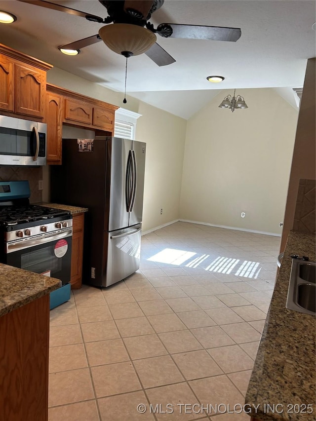 kitchen with light tile patterned flooring, lofted ceiling, decorative light fixtures, appliances with stainless steel finishes, and ceiling fan