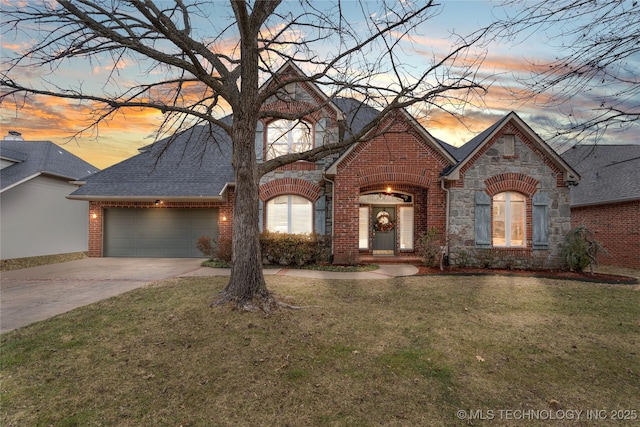 french provincial home featuring a garage and a yard