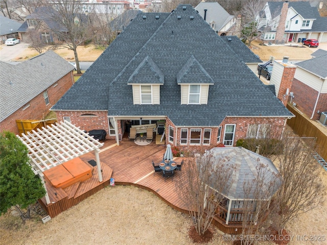 back of property featuring a wooden deck and a jacuzzi