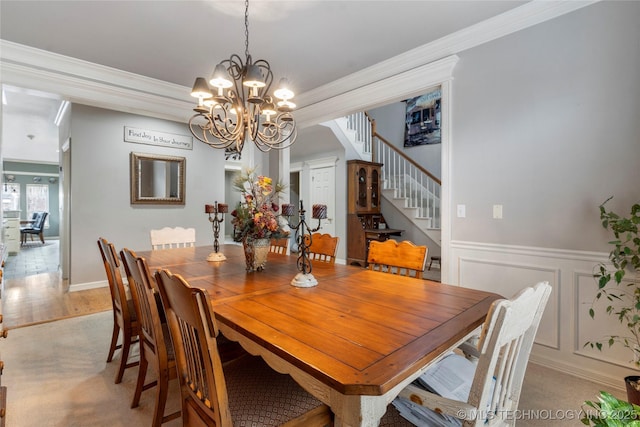 dining area with ornamental molding, an inviting chandelier, and light hardwood / wood-style floors