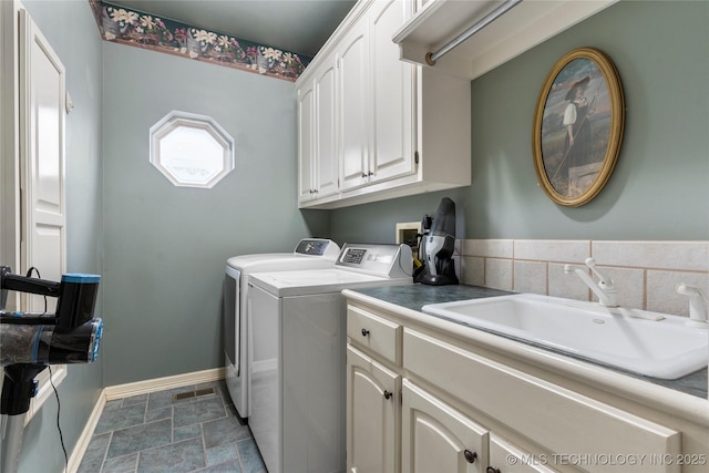 laundry room featuring sink, washing machine and dryer, and cabinets