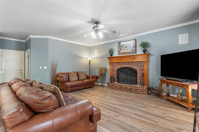 living room featuring ceiling fan, crown molding, a fireplace, and light wood-type flooring