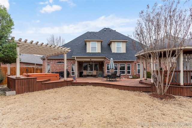 back of house featuring a pergola, a deck, and a covered hot tub