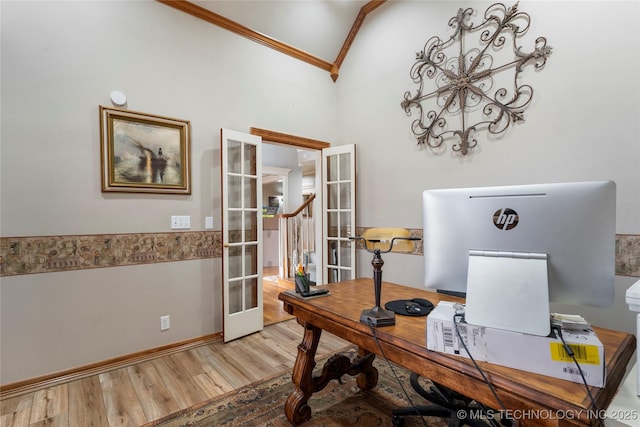 office space with lofted ceiling, light hardwood / wood-style flooring, ornamental molding, and french doors