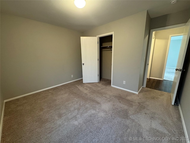 unfurnished bedroom with light colored carpet and a closet