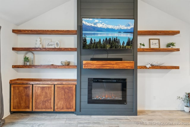 bar with a large fireplace and vaulted ceiling