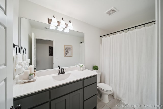 bathroom with tile patterned flooring, vanity, and toilet