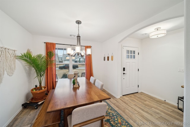 dining area with a chandelier and light hardwood / wood-style flooring