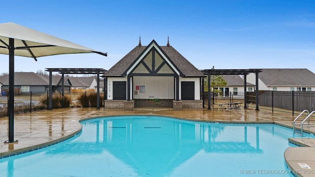 view of pool featuring a pergola, an outdoor structure, and a patio