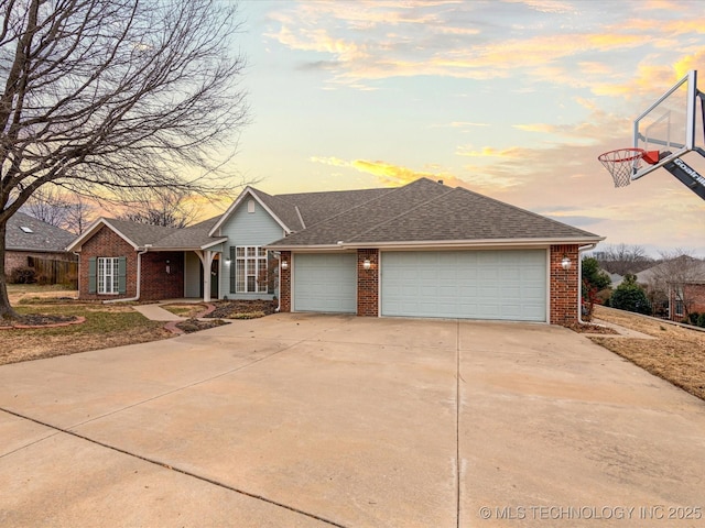 ranch-style house featuring an attached garage, roof with shingles, concrete driveway, and brick siding
