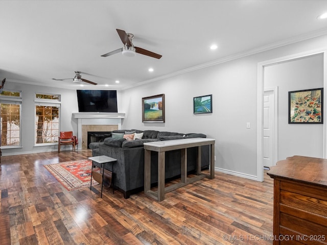 living area with ornamental molding, a ceiling fan, and wood finished floors