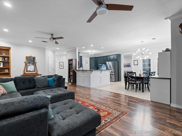 living room with visible vents, crown molding, recessed lighting, light wood finished floors, and ceiling fan with notable chandelier