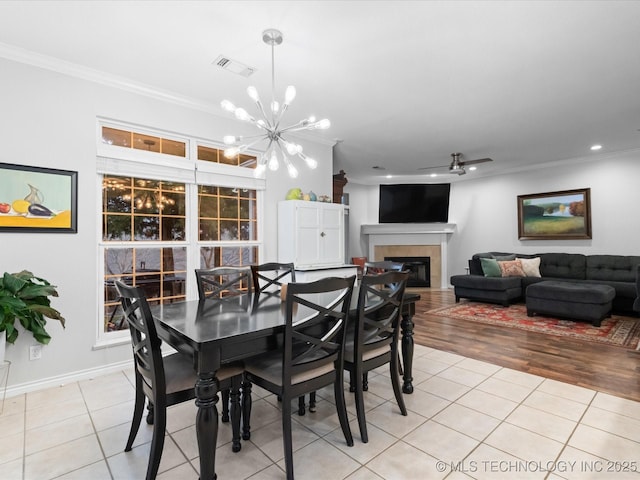 dining area featuring crown molding, light tile patterned floors, and visible vents