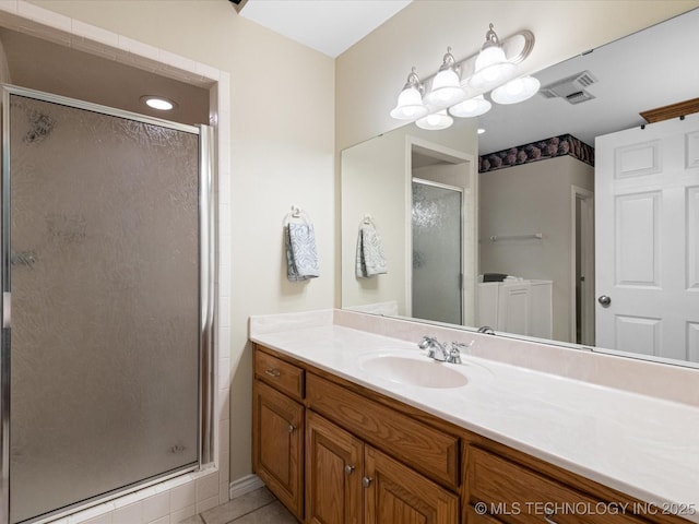 full bathroom with visible vents, tile patterned floors, a stall shower, and vanity