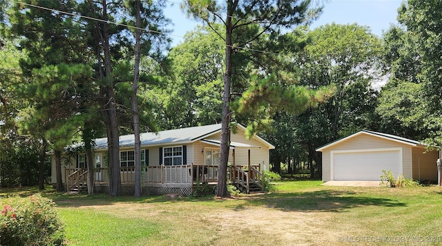 view of front of house with a garage, an outbuilding, and a front lawn