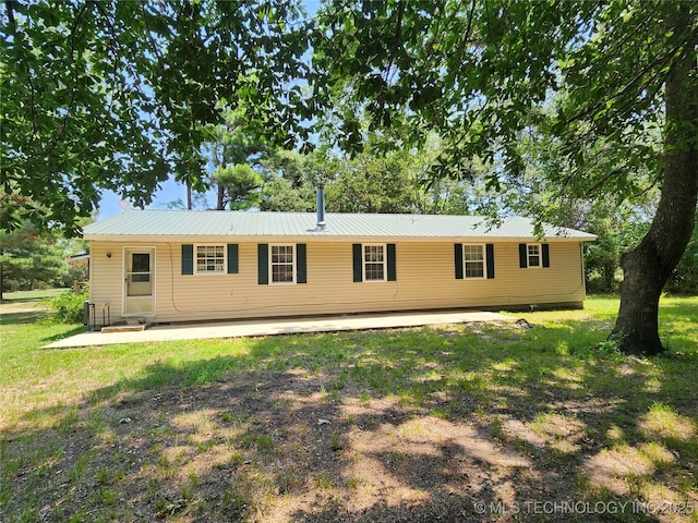 rear view of property featuring a patio and a lawn